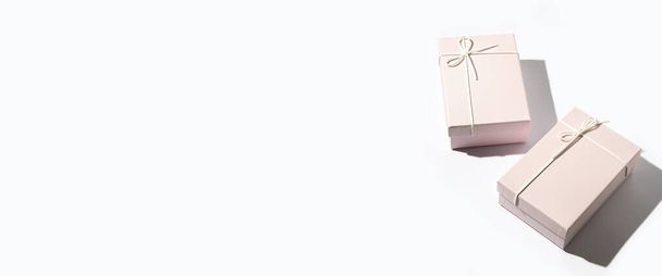 Дві рожеві коробки з подарунками на білому тлі. Верхній вид, плоский. Банер. - Фото, зображення