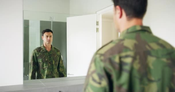 Soldaat in de badkamer in de ochtend met spiegel, uniform en camouflage klaar voor bootcamp. Legerkazerne toilet, strijd en militaire man op zoek naar reflectie met moed, loyaliteit en service - Video