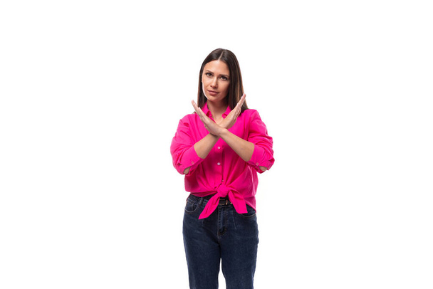 jonge werknemer kantoor vrouw gekleed in een roze shirt gekruist haar armen voor haar op een witte achtergrond met kopieerruimte. - Foto, afbeelding