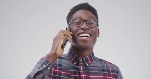 Telefon görüşmesi, gülümseme ve beyaz bir stüdyoda sohbet, iletişim ve tartışma ile siyah bir adam. Afrikalı kişi, akıllı telefon ile iletişim ve model, sohbet ve internet ağı. - Video, Çekim