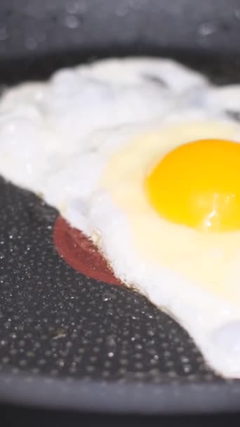 Ein Ei in einer Pfanne kochen. Kochen. Spiegelei. Vertikales Video. - Filmmaterial, Video