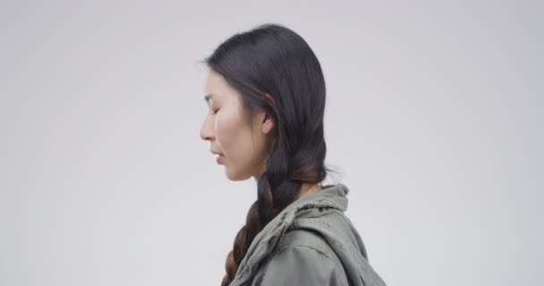 Sad, crying and an Asian woman with depression in studio isolated on a white background. Tears, crisis and person with anxiety, stress and broken heart, trauma and grief, mistake and mental health. - Footage, Video