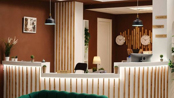 Lege stijlvolle, gezellige loungeruimte met gezellige groene stoelen en een bank klaar om bezoekers te verwelkomen. Reisaccommodatie resort check-in receptie, jib up shot - Foto, afbeelding