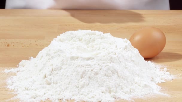 Łamanie jajko w kupę mąki - Materiał filmowy, wideo
