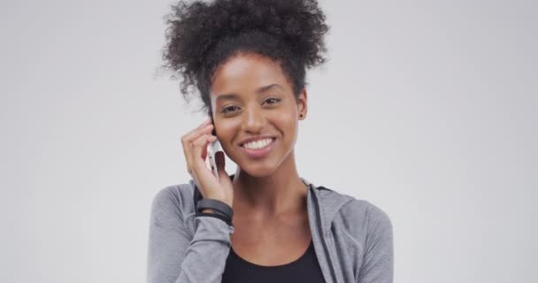 Gesicht, Frau und Lächeln im Studio zum Telefonieren, Kontaktieren und Lachen für Witz auf weißem Hintergrund. Afrikanisches Mädchen, Smartphone und lustige Kommunikation für soziale Netzwerke, Klatsch und Handygespräche. - Filmmaterial, Video