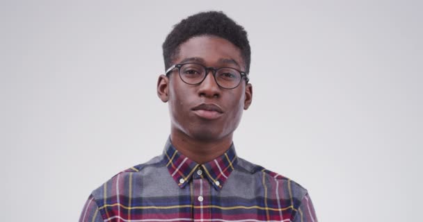 Serious black man, glasses and face of nerd or geek isolated against a studio background. Portrait of smart African person or casual model looking with spectacles, blank stare or eyewear on mockup. - Footage, Video