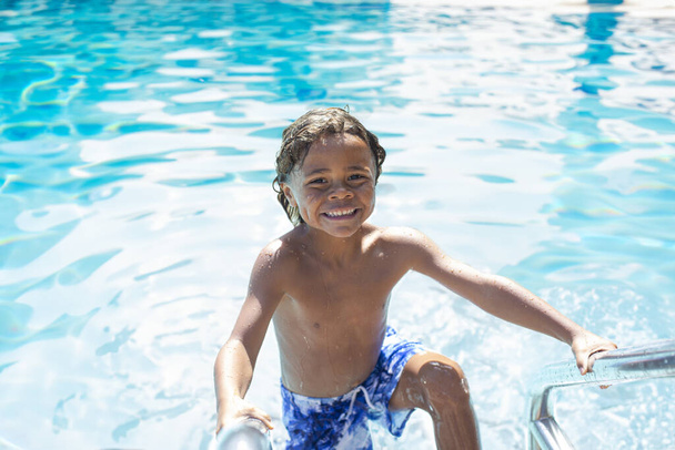 Lächelnder kleiner Junge hat im Urlaub Spaß im Schwimmbad - Foto, Bild