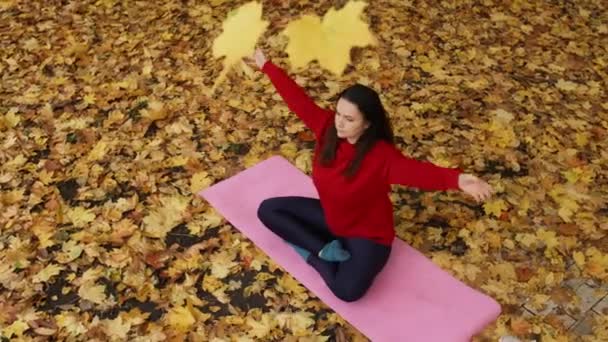 Az őszi ragyogásban sütkérezni: egy derűs jóga elvonulás a levelek aranylombkoronáján. Kiváló minőségű 4k felvételek - Felvétel, videó