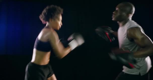 Box, rukavice a boj o fitness s černým párem v ateliéru na tmavém pozadí pro zdraví. Boj, sebeobrana nebo zápasení s mužem a ženou boxer v cvičení nebo tréninku. - Záběry, video