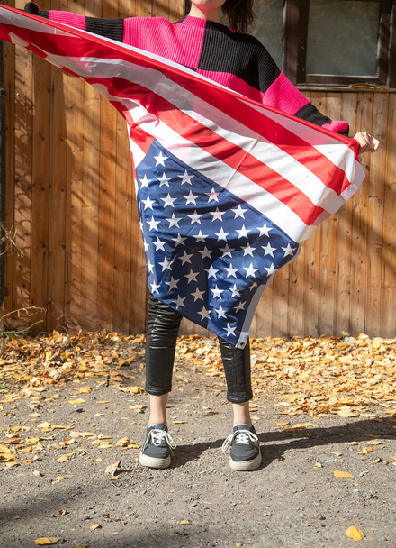 Mujer joven caucásica con una bandera de nosotros. - Foto, imagen