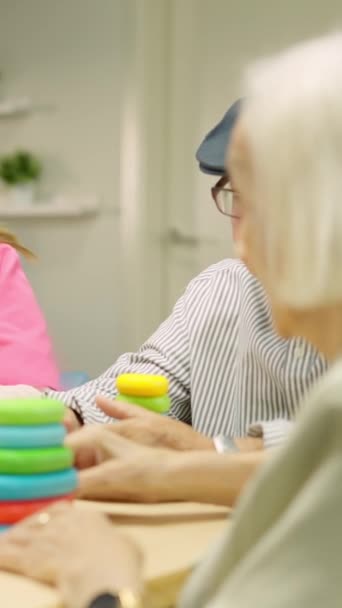 Video de una enfermera ayudando a un hombre mayor a resolver un juego de habilidad en una geriatría - Imágenes, Vídeo