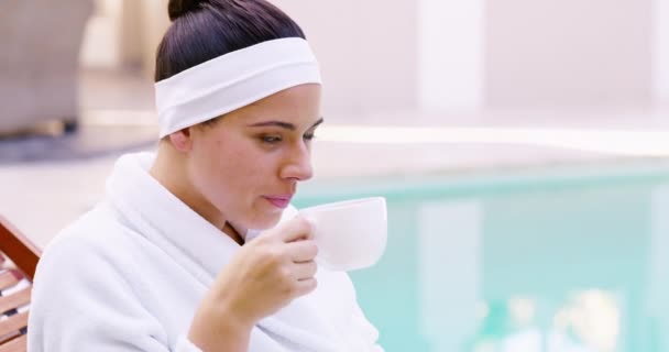Happy woman, coffee and relax at spa for luxury getaway, stress relief or outdoor morning treatment. Calm female person smile, drinking tea or beverage at hotel or salon in zen, vacation or holiday. - Footage, Video