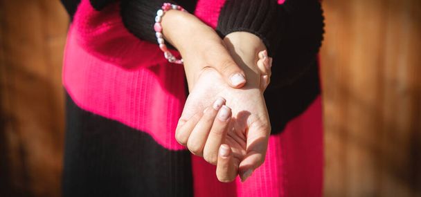 Fiatal kaukázusi nő szenved fájdalom a kezében. - Fotó, kép