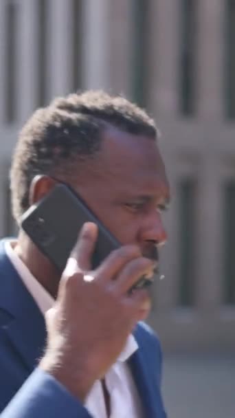 Βίντεο ενός ώριμου αφρικανού επιχειρηματία που μιλάει στο κινητό εξωτερικό χώρο - Πλάνα, βίντεο