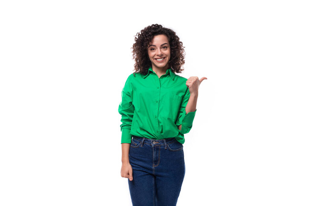 giovane signora caucasica con riccioli neri vestiti con una camicia verde sta gesticolando attivamente su uno sfondo bianco con spazio copia. - Foto, immagini