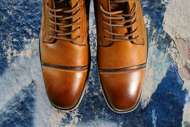 Un par de botas de piel de becerro premium sobre un fondo azul. Disparo horizontal. Ideas de zapatos para hombre. - Foto, Imagen