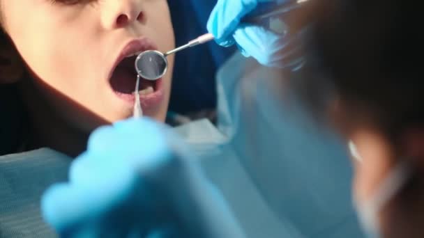 οδοντίατρος που εξετάζει τα δόντια του αγοριού με εργαλεία οδοντιατρικής  - Πλάνα, βίντεο