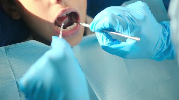 οδοντίατρος που εξετάζει τα δόντια του αγοριού με εργαλεία οδοντιατρικής  - Πλάνα, βίντεο