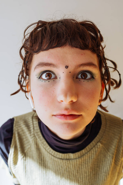 портрет подростка неформальное движение, крупным планом, с маленькими косичками, с чернилами на лице - Фото, изображение