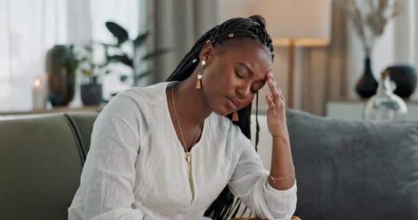Headache, burnout and young black woman in the living room of her modern apartment on weekend. Stress, mental health and sick African female person with migraine for illness in lounge at home - 映像、動画