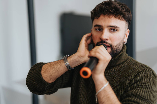 A man standing in an office, singing into a microphone while his colleagues watch. He is taking a break from work and enjoying some fun times with positive atmosphere. - Photo, Image