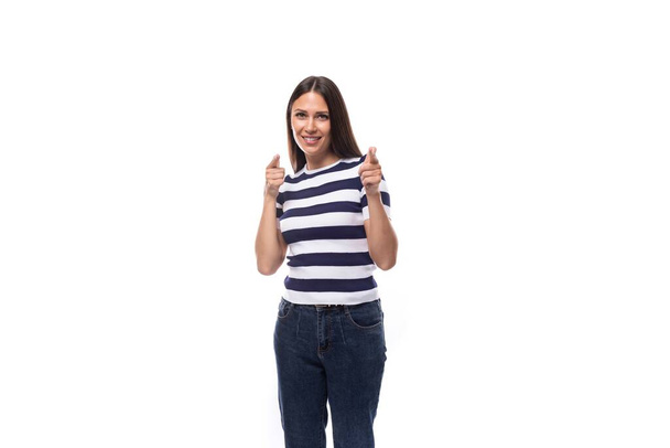 leuke jonge Europese vrouw met zwart recht haar draagt gestreept zwart-wit t-shirt en jeans in de zomer. mensen kleding concept. - Foto, afbeelding