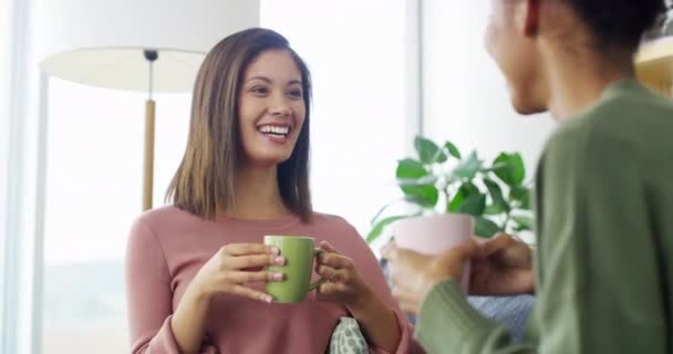 Coffee, conversation and young women in the living room bonding, laughing and talking together. Happy, smile and girl friends drinking a latte, cappuccino or tea and speaking in the lounge at home - Footage, Video
