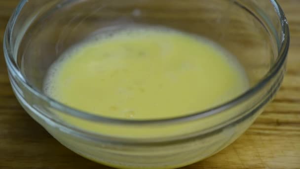 Dompel de geprepareerde, geschilde, rauwe garnalen in het geklopt ei. Een aflevering van een reeks recepten voor het maken van gepaneerde gebakken garnalen. Een close-up. Real time - Video