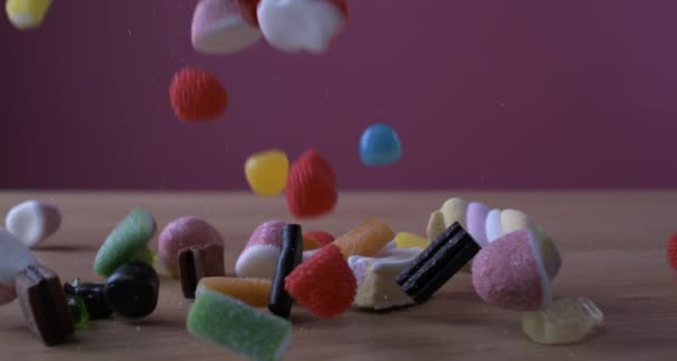 Variety of SWEETENED FOAM SUGAR assortment of candies falling on table in super slow-motion captured with high-speed camera - 映像、動画