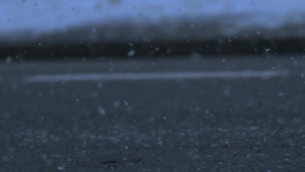 Winter Snowfall in Super Slow Motion , snowflakes falling into asphalt road sidewalk - Séquence, vidéo