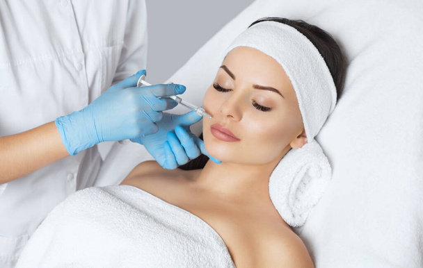 Lääkäri kosmetologi tekee Lip augmentation menettely kaunis nainen kauneushoitolassa.Kosmetologia ihonhoito. - Valokuva, kuva