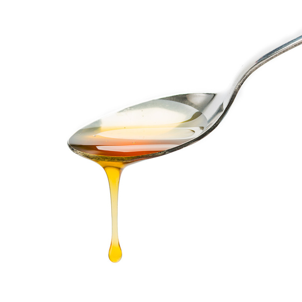 Lepel met honing drop - Foto, afbeelding