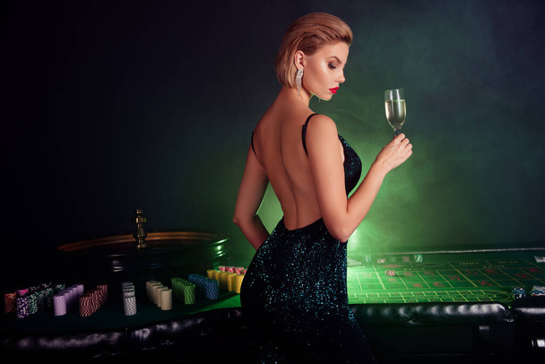Foto de impresionante chica rica chic celebrar la victoria del póquer en vip casino club levantar copa de vino cóctel. - Foto, Imagen