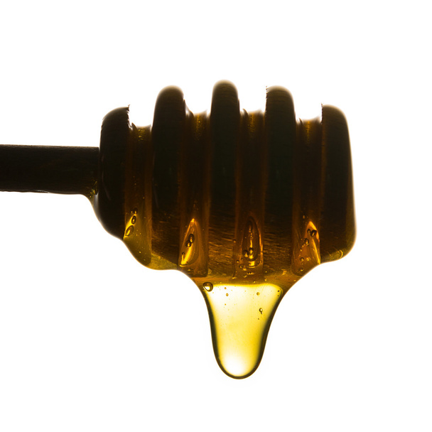 Золота крапля меду на дерев'яному мряці
 - Фото, зображення