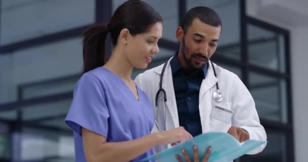 Doctor, nurse and discussion of documents, hospital folder and feedback of patient history, results or report. Man, woman and team planning healthcare advice, medical information and review paperwork. - Footage, Video