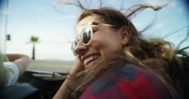 Adventure, travel and girl friends on road trip for holiday, vacation or weekend together. Happy, freedom and young women driving a car in wind for transportation, tourism or sightseeing by coast - Footage, Video