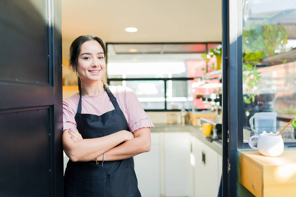 Felice bella giovane donna e imprenditore con un grembiule sorridente mentre apriva la sua caffetteria - Foto, immagini