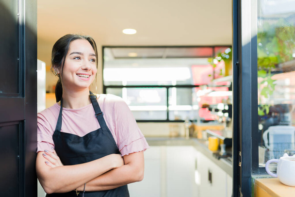 Gut gelaunte attraktive Inhaberin und Unternehmerin eröffnet ihr Geschäft, während sie im schönen Café arbeitet - Foto, Bild