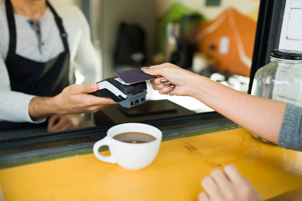 Mujer latina y cliente pagando con un crédito después de comprar café en la cafetería  - Foto, Imagen