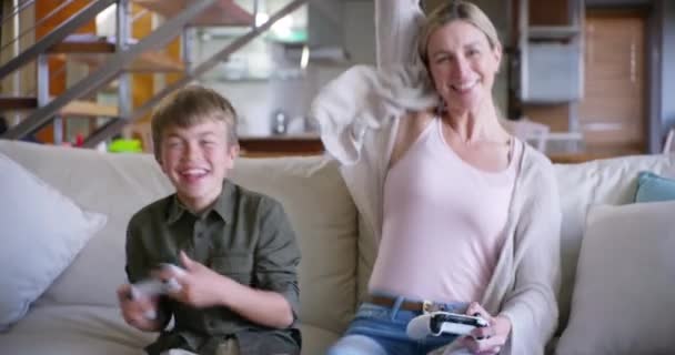 Mother, son and video games in home with celebration, happiness and bonding on sofa in living room. Family, woman and child with gaming, winner and excited on couch in lounge, house or apartment. - Footage, Video