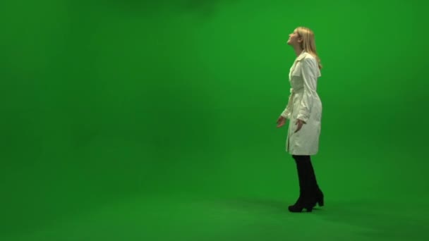 Woman walking on green background - Filmati, video