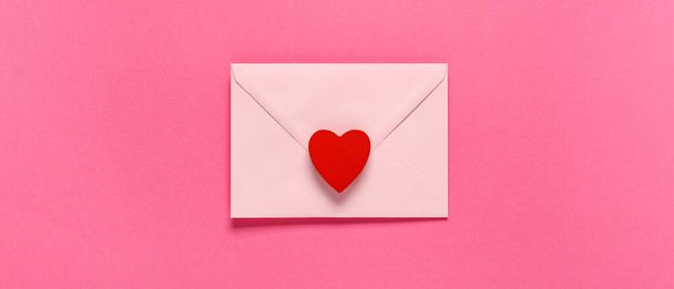 Envelope e coração vermelho sobre fundo rosa, vista superior. Celebração do Dia dos Namorados - Foto, Imagem