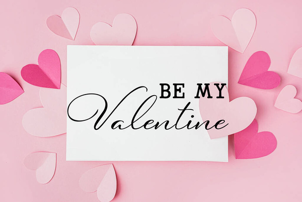Beautiful greeting card for Valentine's Day with paper hearts on pink background - Photo, Image