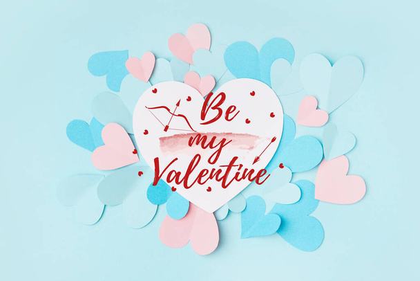 Mooie wenskaart voor Valentijnsdag met papieren hartjes op lichtblauwe achtergrond - Foto, afbeelding