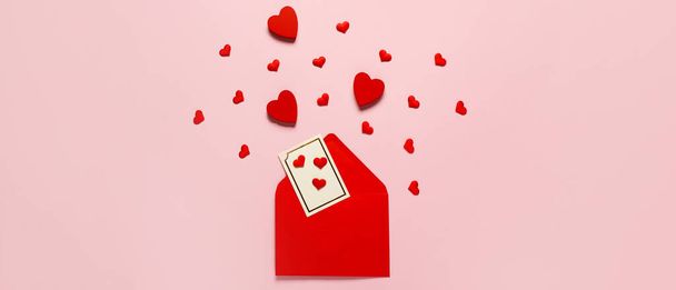 Composition avec enveloppe rouge et coeurs sur fond rose, vue de dessus. Fête de la Saint-Valentin - Photo, image