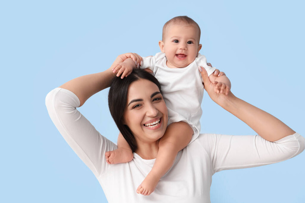 Щаслива мати зі своєю дитиною на синьому фоні - Фото, зображення