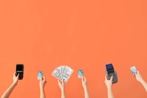 Mulheres com cartões de crédito, terminais de pagamento e notas de dólar em fundo laranja - Foto, Imagem