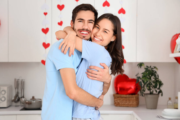 Felice giovane coppia che si abbraccia in cucina a San Valentino - Foto, immagini