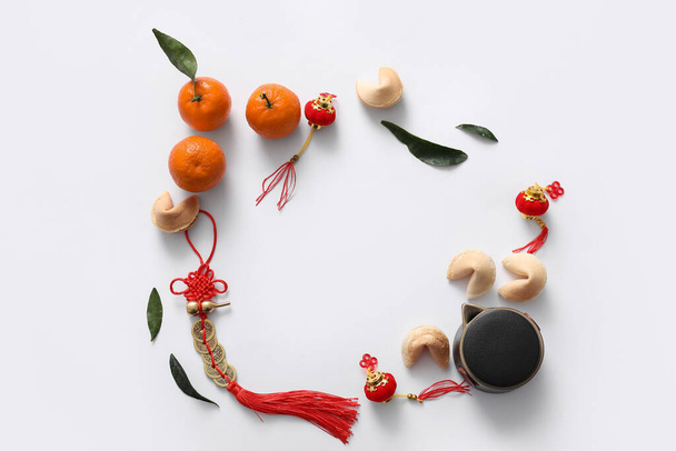 Frame made from tangerines, fortune cookies and Chinese symbols on white background. New Year celebration - Photo, Image