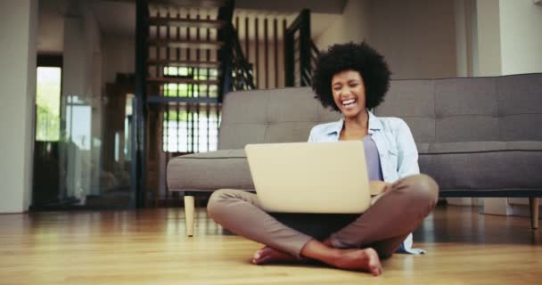 Hauska, videopuhelu ja musta nainen keskustella kotona lattialla olohuoneessa tai asunnossa. Henkilö, nauraa ja vaikuttaa kannettavan tietokoneen webinar, streaming verkossa ja viestintä lounge rentoutua. - Materiaali, video